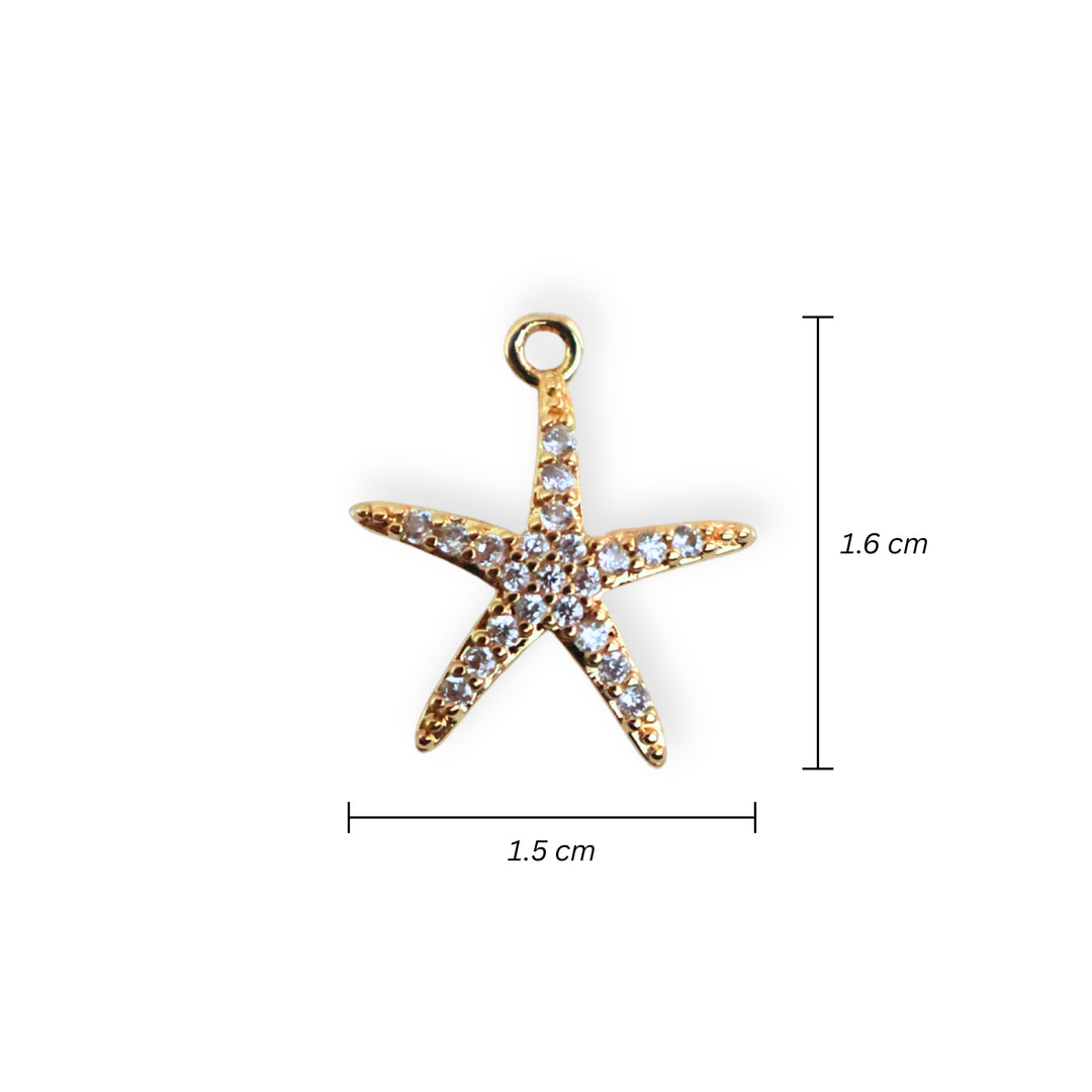 Medidas para dije de estrella de mar en chapa de oro con zirconias alrededor sobre fondo blanco