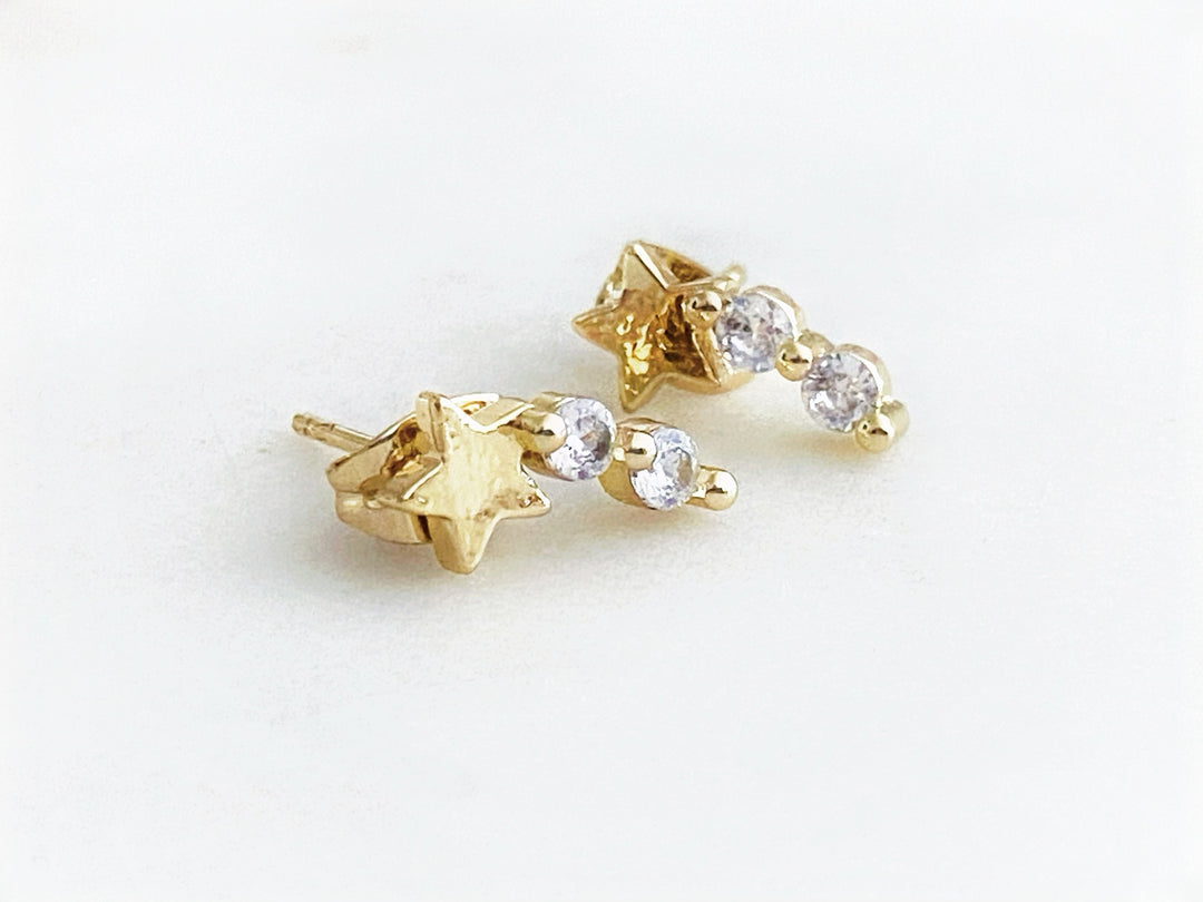 Aretes Estelar en chapa de oro con estrella y zirconias brillantes sobre fondo blanco