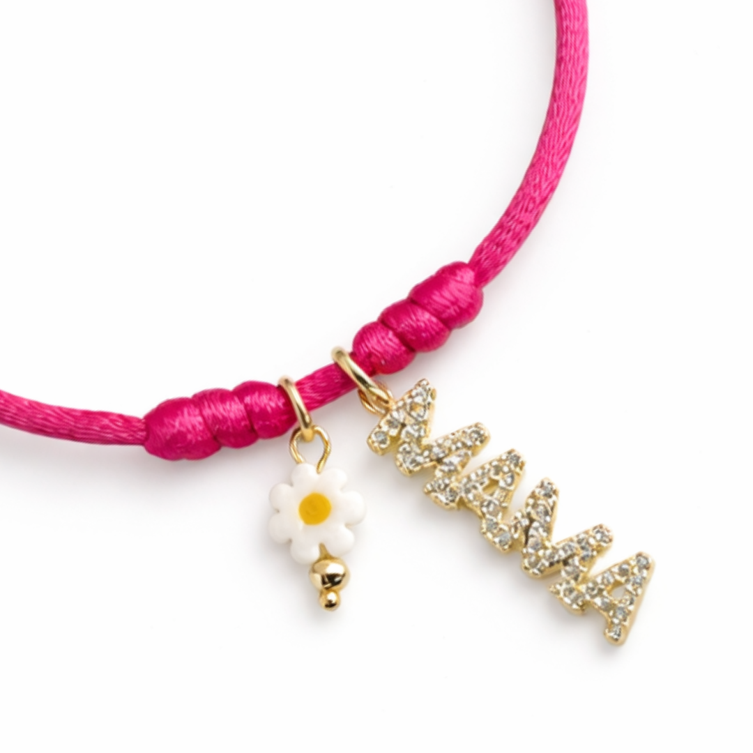 Pulsera ajustable de hilo fucsia con dije dorado “mamá” y flor metálica de murano, vista completa.