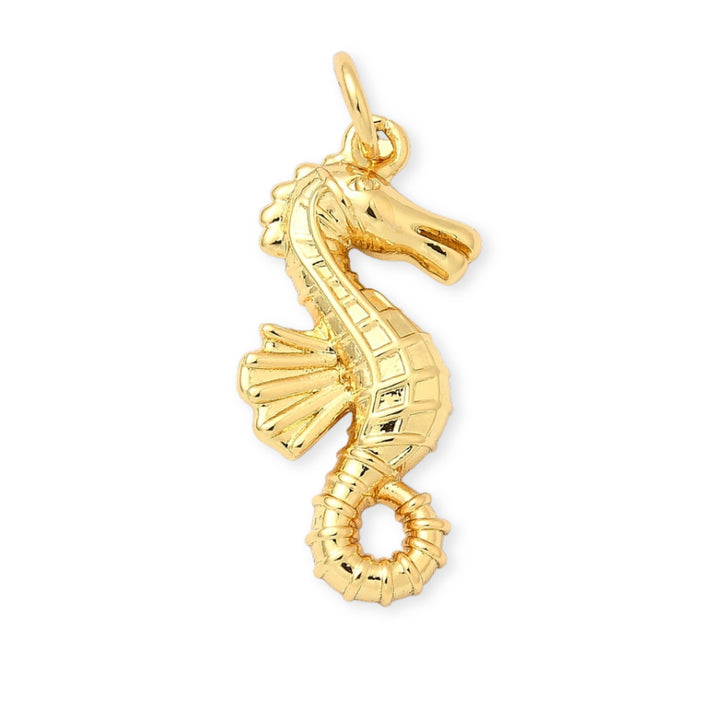 Dije dorado en forma de caballito de mar sobre fondo blanco