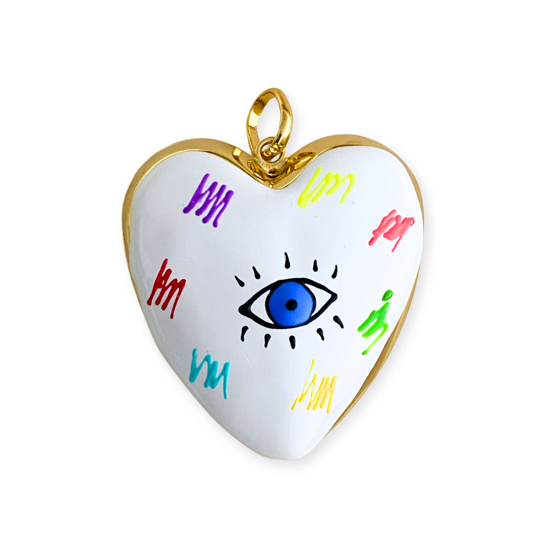 Dije grande de corazón esmaltado blanco con ojo central y detalles multicolor en chapa de oro. 