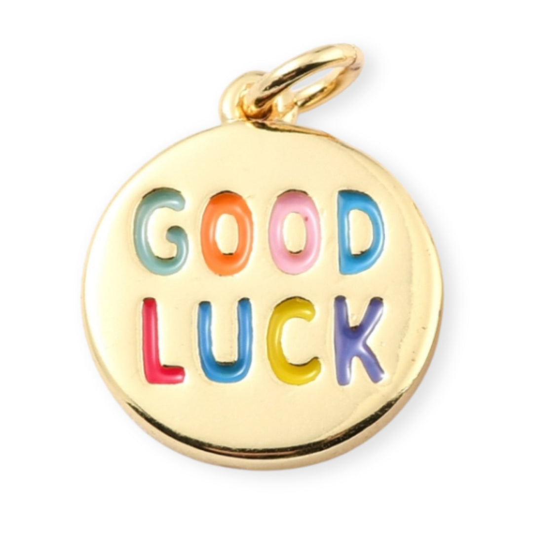 Dije circular dorado con grabado “Good Luck” y esmaltado en colores vivos