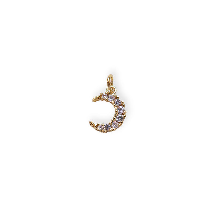 Dije dorado en forma de luna con zirconia.