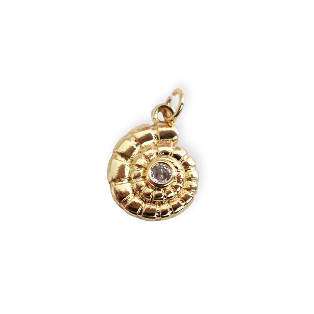 Dije de caracol en chapa de oro con zirconia al centro sobre fondo blanco