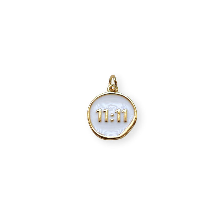 Dije circular dorado con “11:11” esmaltado en blanco