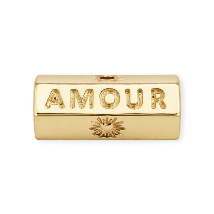 Separador de chapa de oro grabado con la palabra "AMOUR" sobre fondo blanco