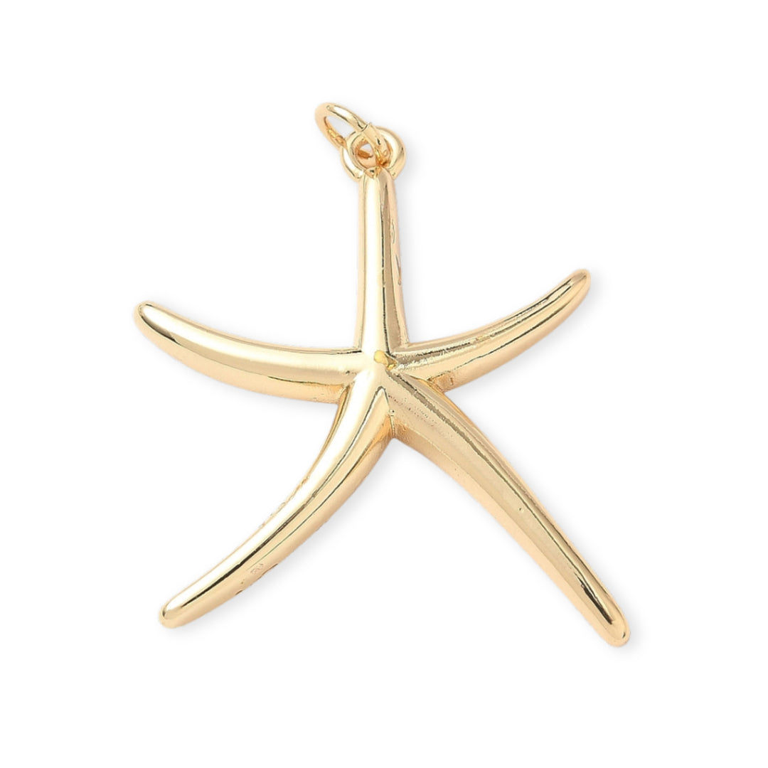 Dije en forma de estrella de mar elaborado en chapa de oro sobre fondo blanco