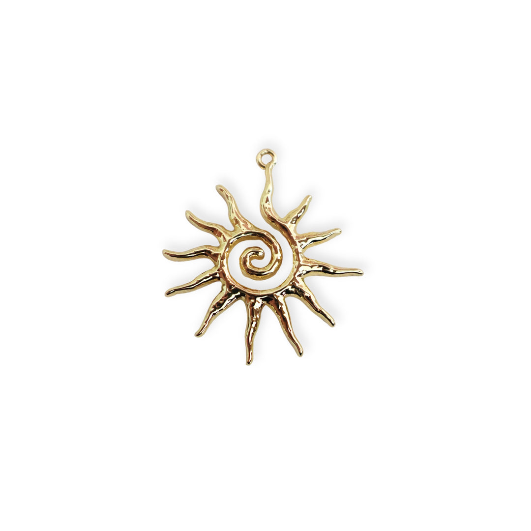Dije en forma de sol con espiral central elaborado en chapa de oro sobre fondo blanco