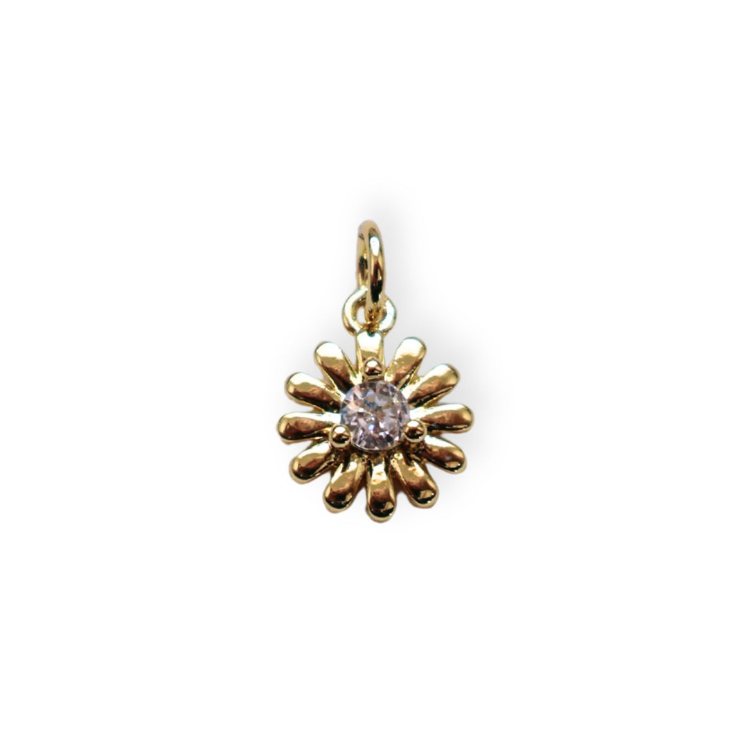Dije dorado en forma de flor con zirconia brillante al centro