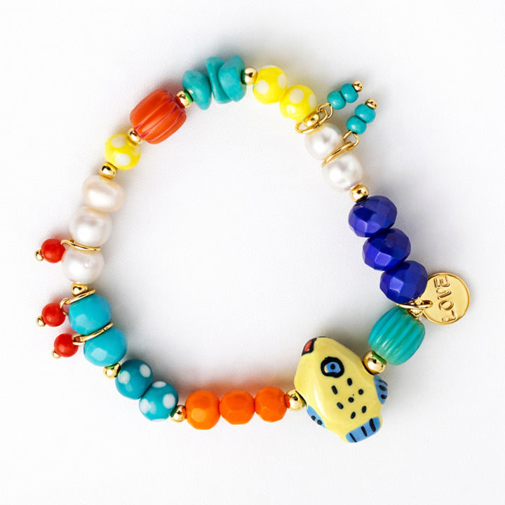 Brazalete marino con pez de cerámica, perla cultivada y dije Love de chapa de oro