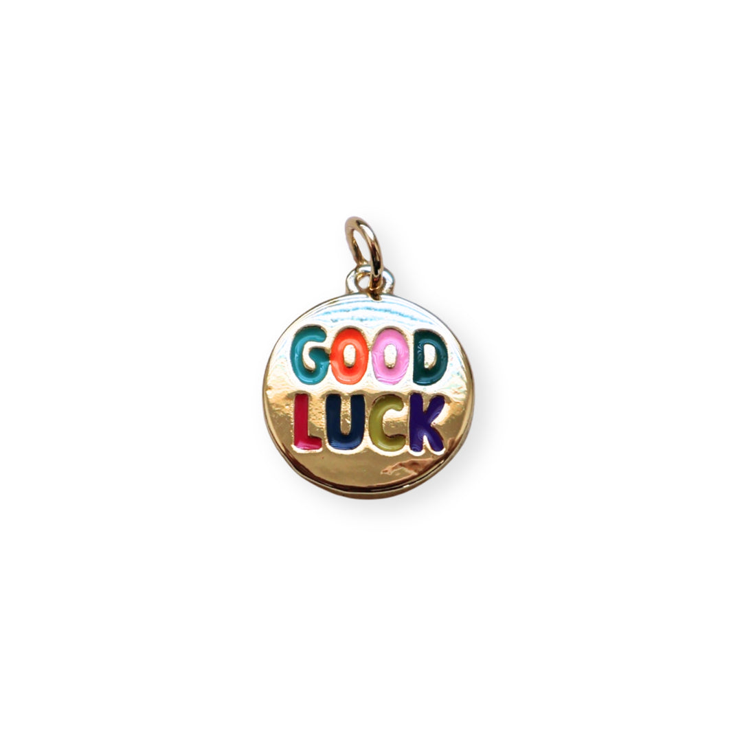 Dije circular dorado con grabado “Good Luck” y esmaltado en colores vivos
