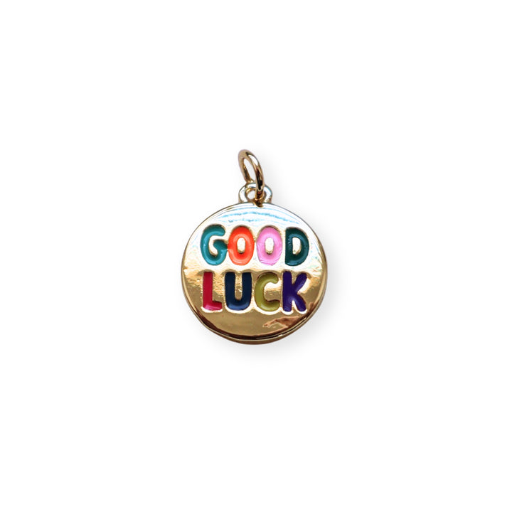 Dije circular dorado con grabado “Good Luck” y esmaltado en colores vivos