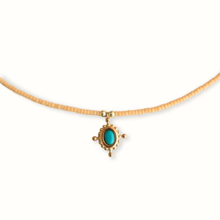 Collar Melora con chaquira dorada y dije de cruz con piedra turquesa
