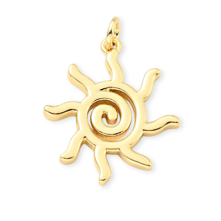 Dije en forma de sol de chapa de oro sobre fondo blanco