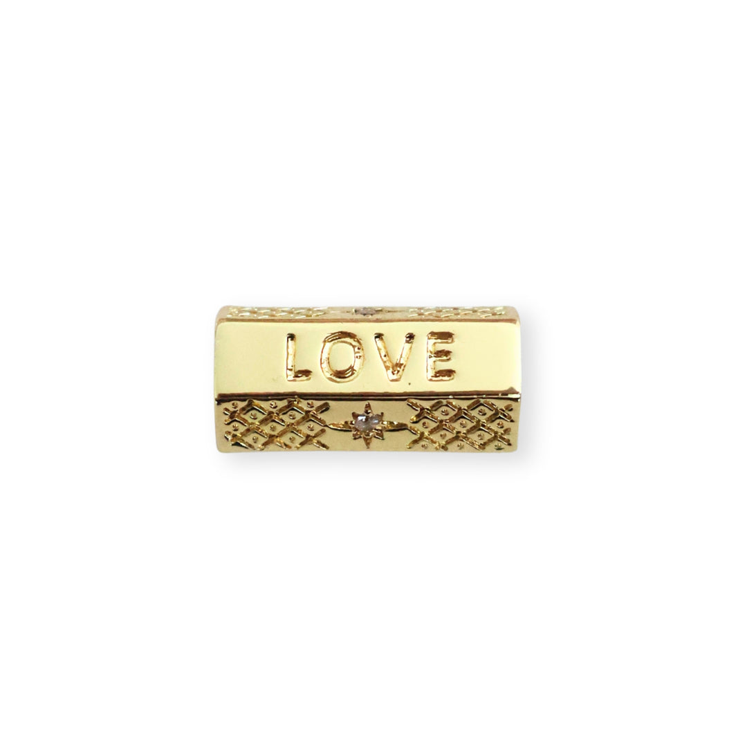 Separador de chapa de oro con grabado "THIS IS LOVE" y zirconia sobre fondo blanco