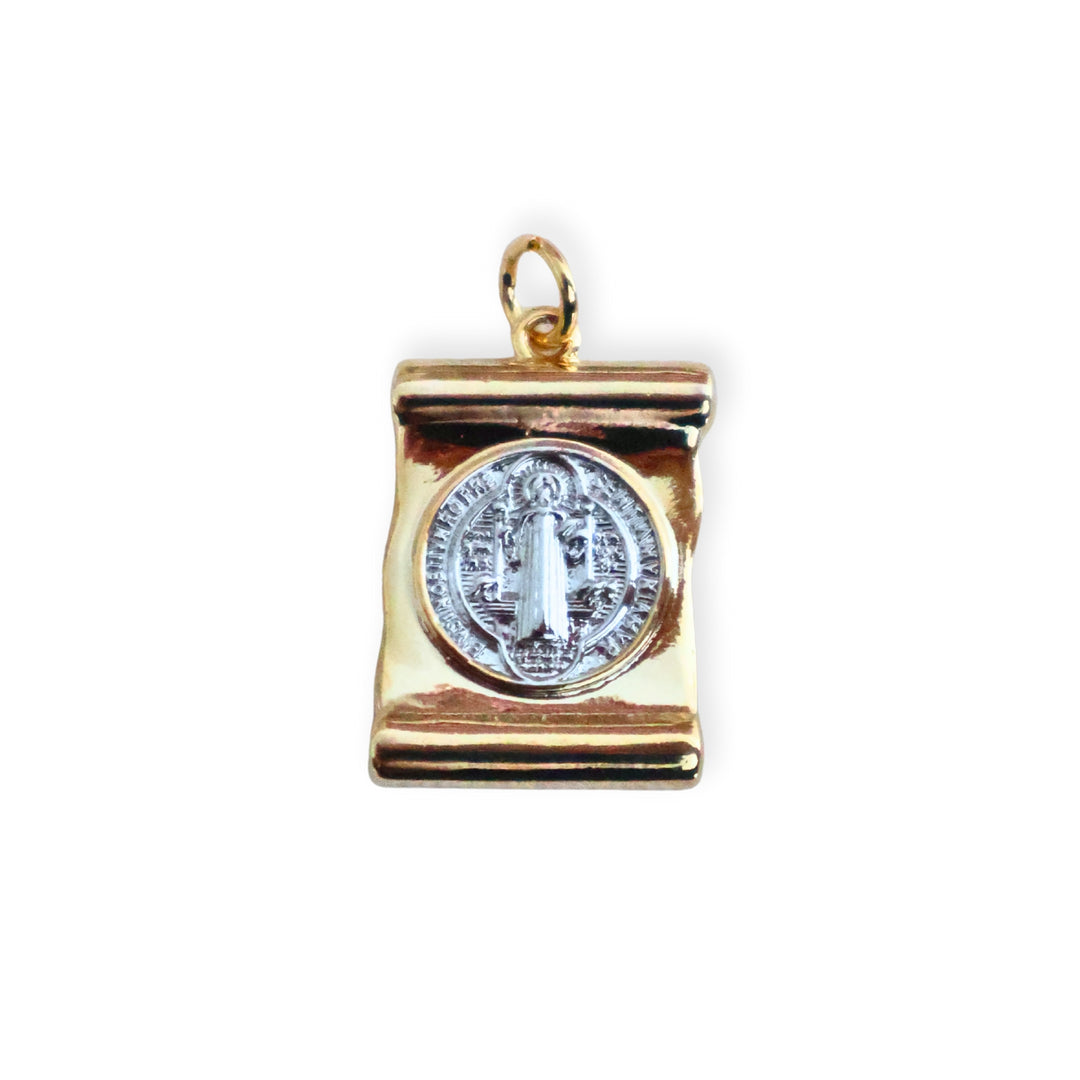 Dije de San Benito en chapa de oro con centro plateado de platino sobre fondo blanco