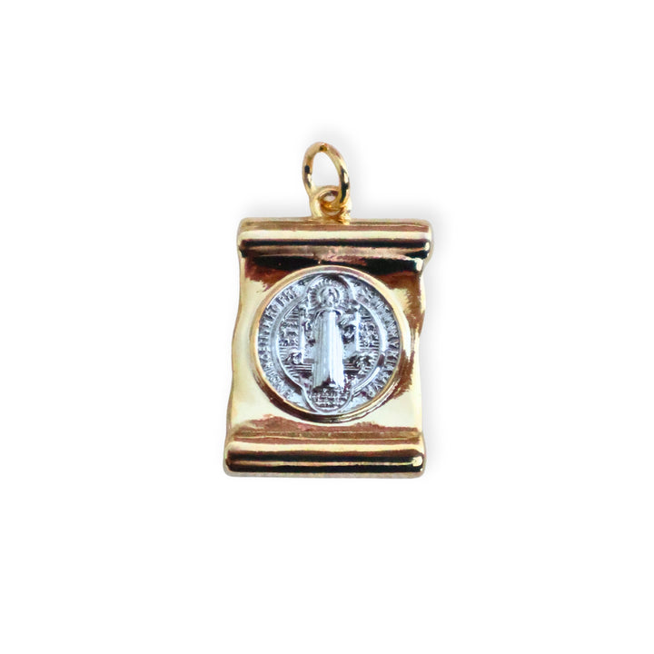 Dije de San Benito en chapa de oro con centro plateado de platino sobre fondo blanco