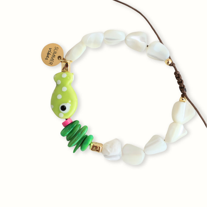 Detalle de Brazalete Lyria con hilo café, madreperla verde y dije de pez verde lima