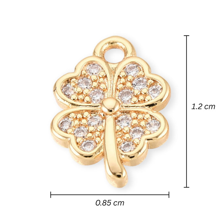 Medidas para Dije dorado en forma de trébol con zirconia al centro sobre fondo claro