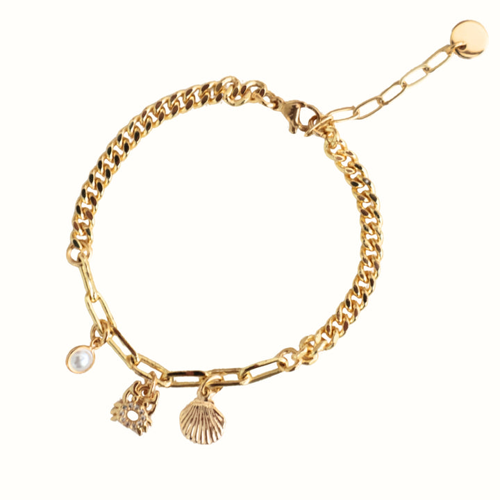 Detalle de Brazalete Elira con cadena dorada, perla de río, cangrejo y concha