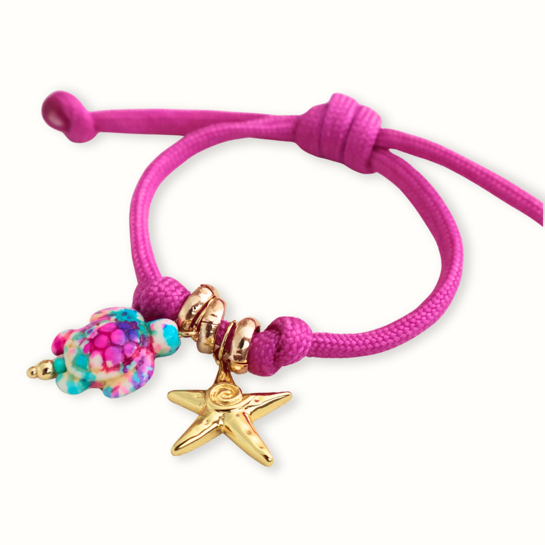 Detalle del dije de tortuga multicolor y estrella de mar en la pulsera Maglara