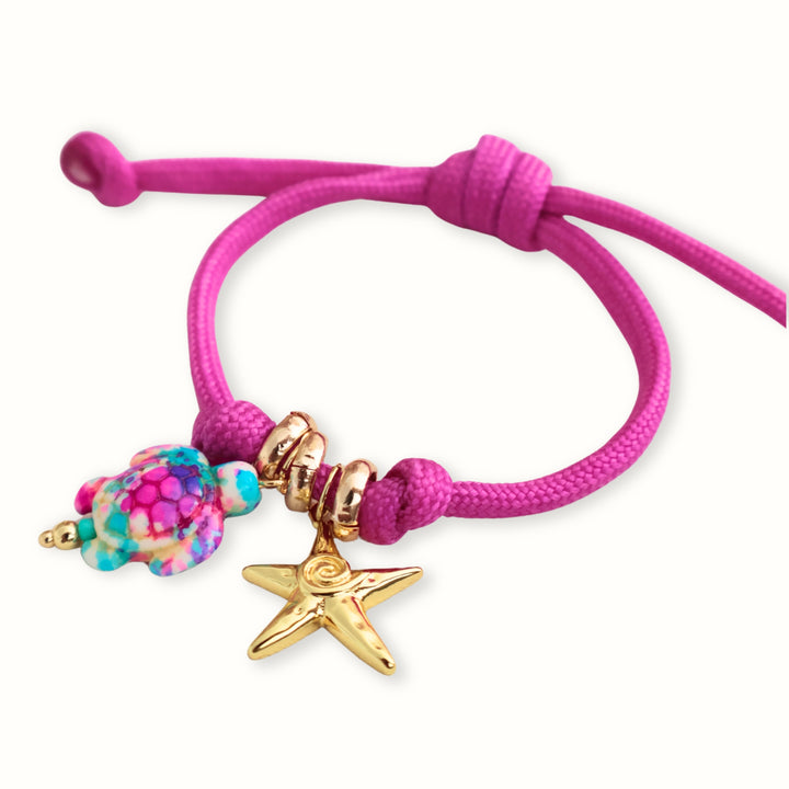 Detalle del dije de tortuga multicolor y estrella de mar en la pulsera Maglara
