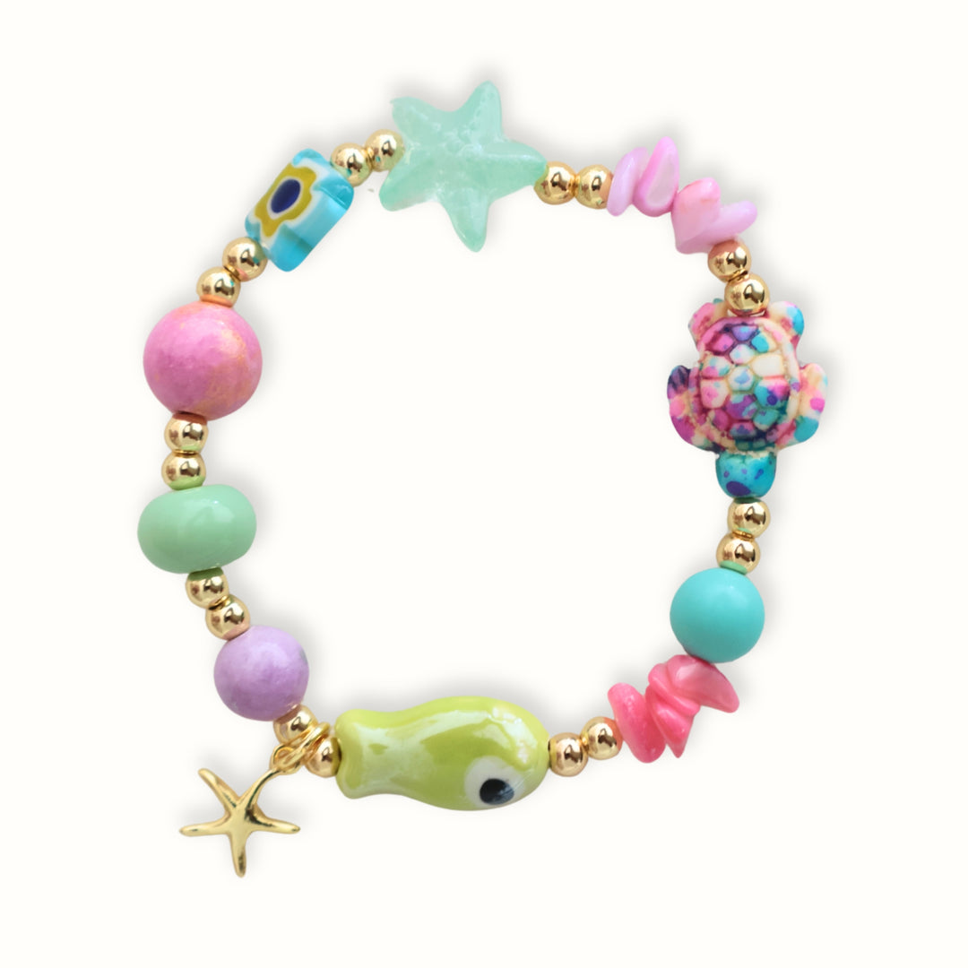 Detalle de Brazalete Calena con piedras naturales pastel, dijes marinos y estrella dorada
