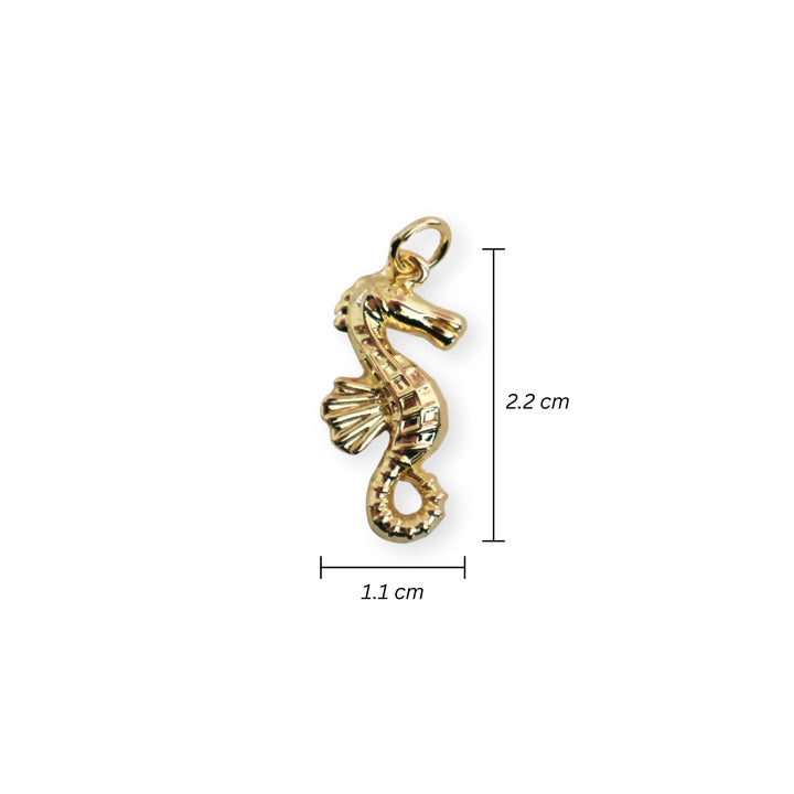 Medidas para dije dorado en forma de caballito de mar sobre fondo blanco
