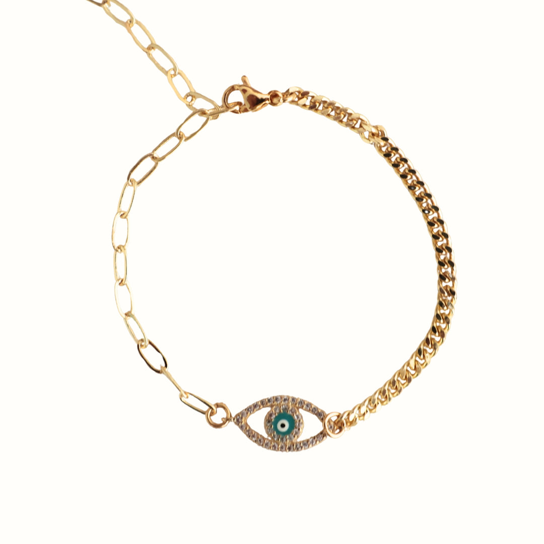 Detalle del dije de ojo dorado con zirconia en el brazalete Luriah