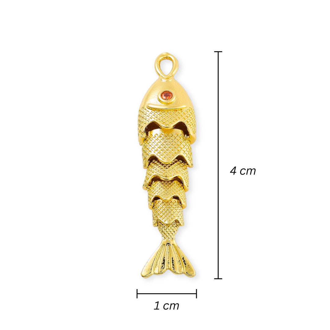 Medidas para Dije dorado en forma de pescado con zirconia roja en el ojo y cuerpo articulado sobre fondo blanco