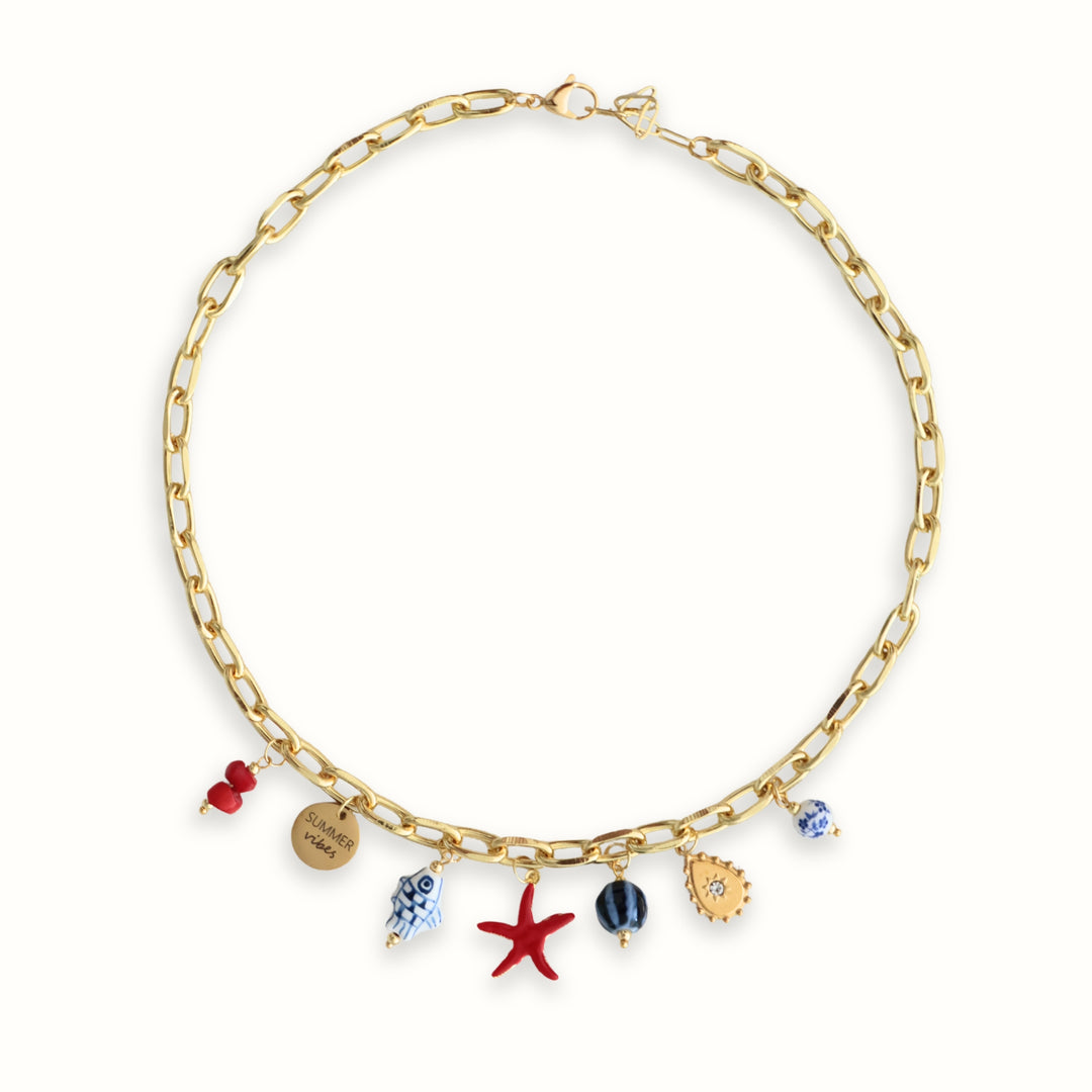 Detalle de Collar Ephyra con estrella de mar roja, cadena dorada y dijes marinos