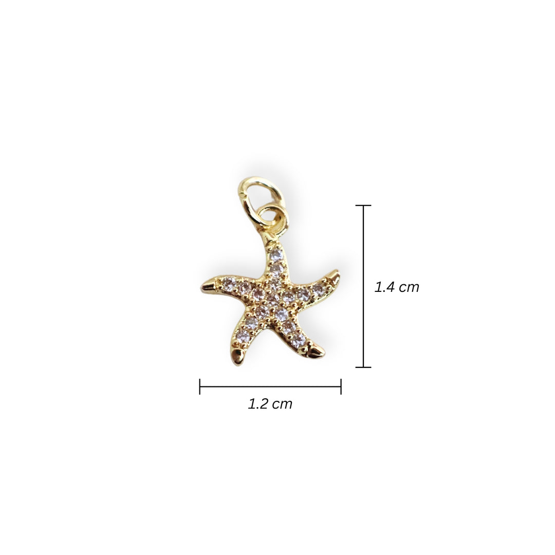 Medidas para dije de estrella de mar en chapa de oro con zirconias alrededor sobre fondo blanco