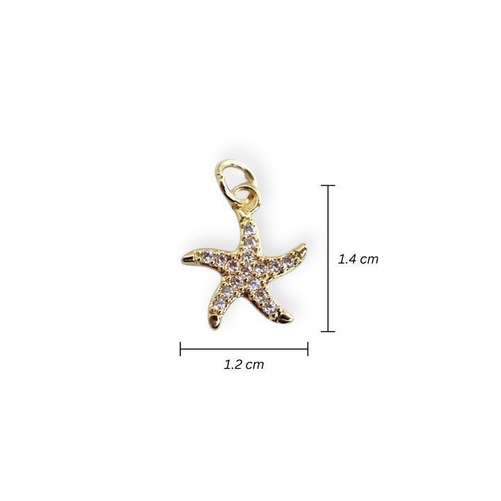 Medidas para dije de estrella de mar en chapa de oro con zirconias alrededor sobre fondo blanco