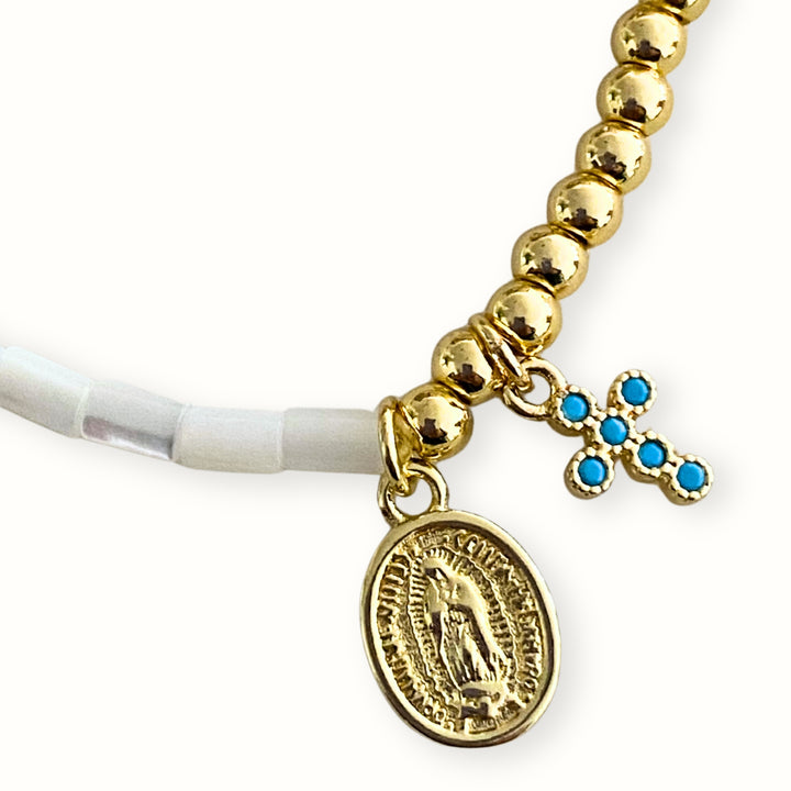 Detalles de Pulsera elástica con madre perla y dijes de cruz y Virgen María en chapa de oro. 