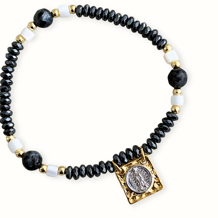 Pulsera elástica con hematita, madre perla y dije de Virgen de Guadalupe en chapa de oro y platino.