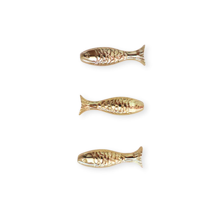 Detalles de separadores en forma de pescado de chapa de oro sobre fondo blanco