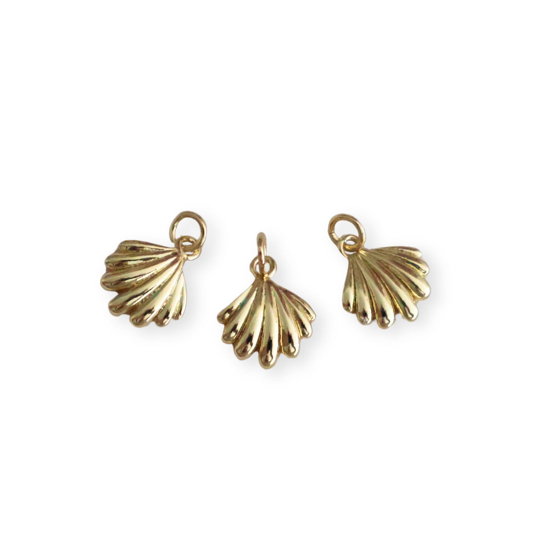 Detalles de dije dorado en forma de concha elaborado en chapa de oro