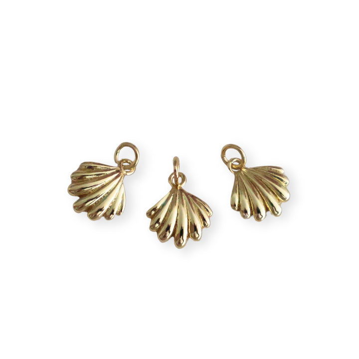 Detalles de dije dorado en forma de concha elaborado en chapa de oro