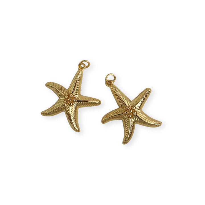 Detalle de dijes en forma de estrella de mar dorada con detalle de bolitas en el centro