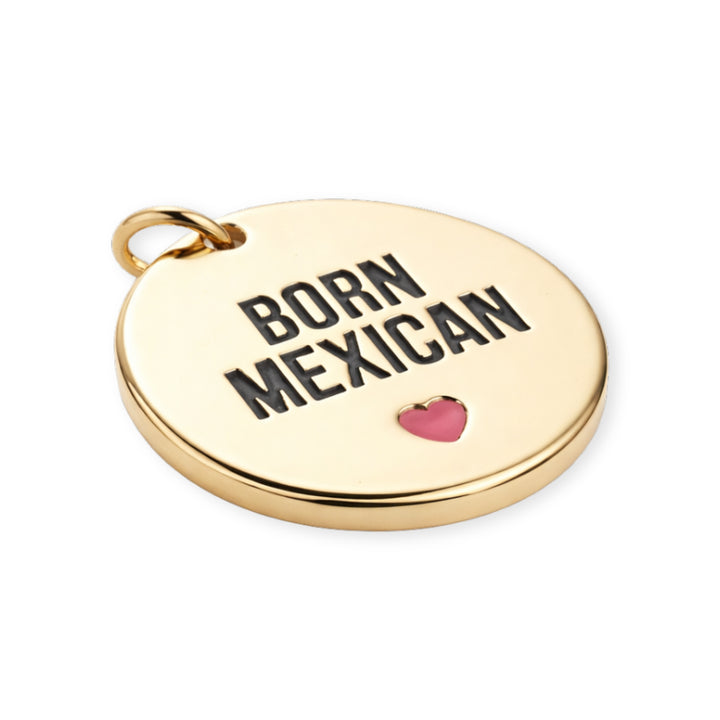 Detalles de Dije redondo de chapa de oro con frase "BORN MEXICAN" y corazón rosa esmaltado sobre fondo blanco