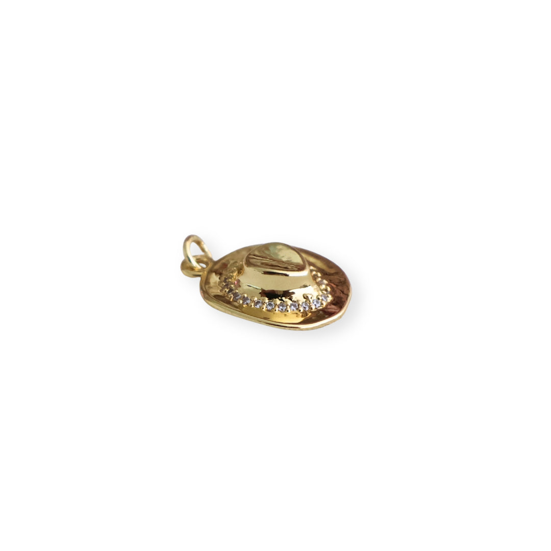 Detalle de dije en forma de sombrero de chapa de oro con zirconia