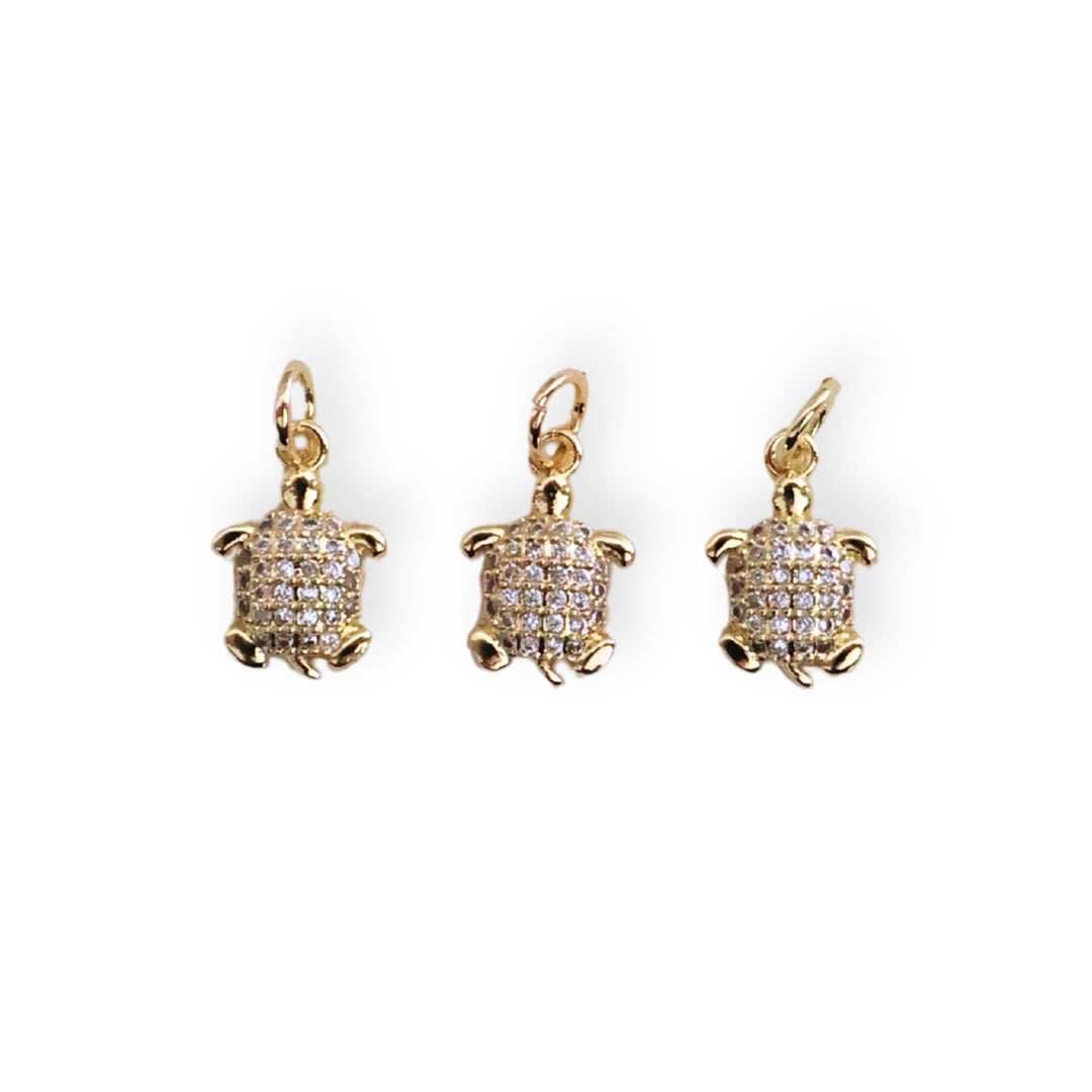 Detalles de dije tortuga en chapa de oro con zirconias brillantes