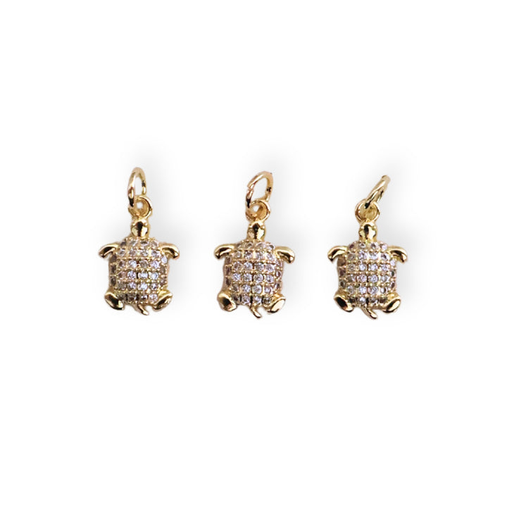 Detalles de dije tortuga en chapa de oro con zirconias brillantes