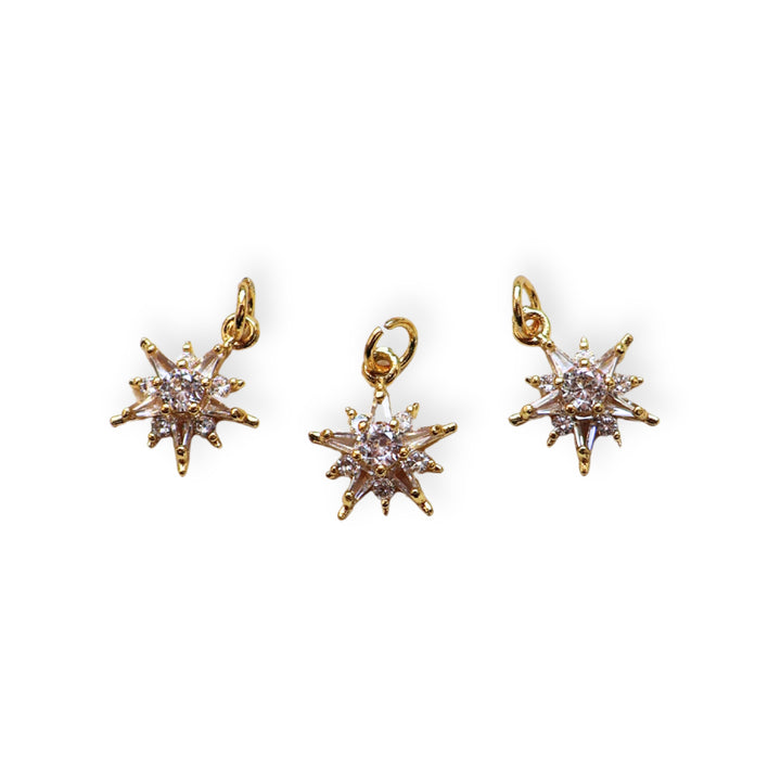 Detalles de dije estrella dorado con zirconia en el centro sobre fondo blanco