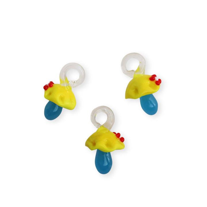 Detalles de dijes de murano en forma de hongo amarillo y azul con flor decorativa en la parte superior