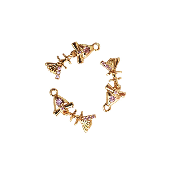 Detalles de dije de pescado de chapa de oro con zirconia rosa en el ojo y aleta móvil sobre fondo blanco