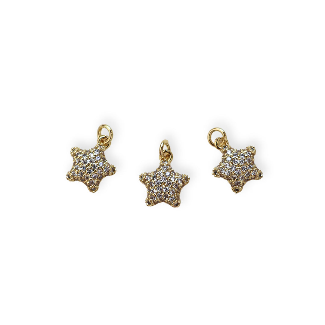 Detalles de dije dorado en forma de estrella con zirconia
