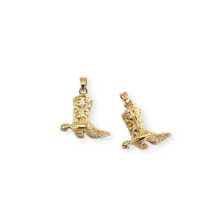 Detalles de dije dorado en forma de bota con zirconias incrustadas