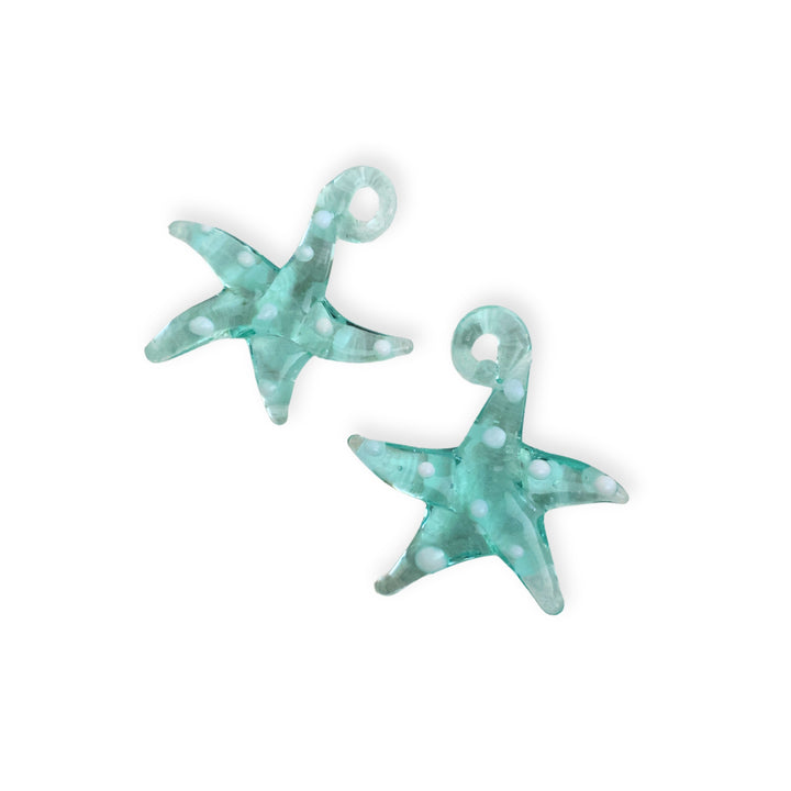 Detalle de dijes de murano en forma de estrella de mar color turquesa con puntos blancos