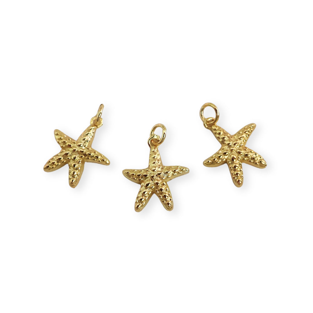 Detalles de dijes dorados en forma de estrella de mar en chapa de oro
